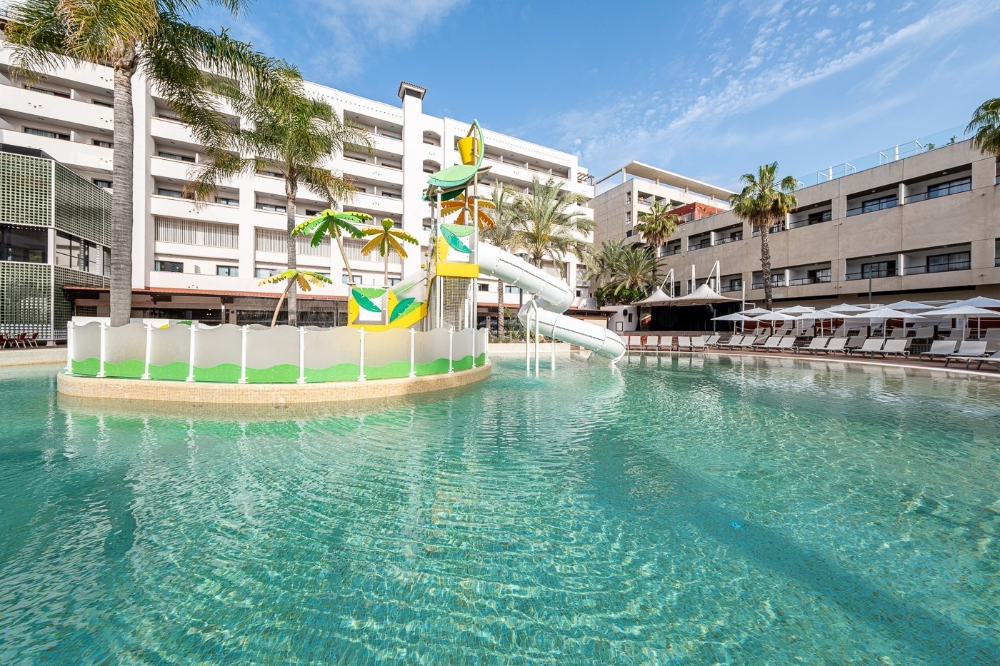 a large white building with a water slide in the middle