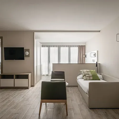 ESTIVAL: Corporate room with double bed, teddy bear, and armchair.