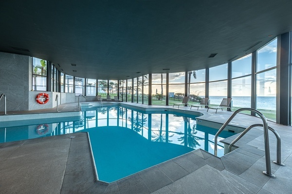 a large indoor swimming pool with a life preserver on the wall