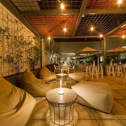 Hotel Vilamari Barcelona | Rooftop lounge with beanbags, tables, and plants.