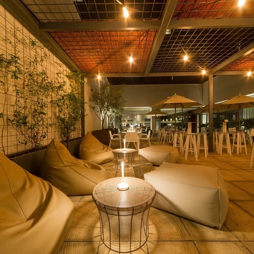 a patio area with bean bag chairs tables and umbrellas