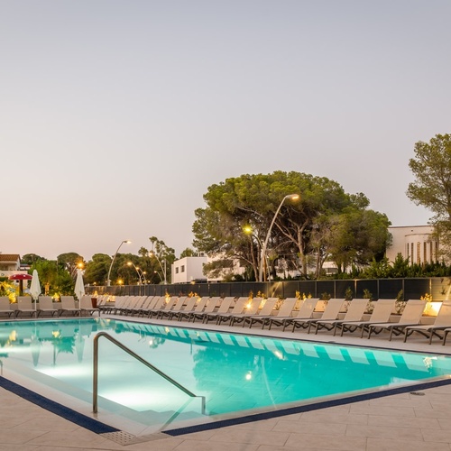 a large swimming pool surrounded by chairs and trees