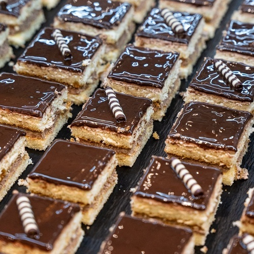 a tray of desserts with chocolate icing and candy sticks on them