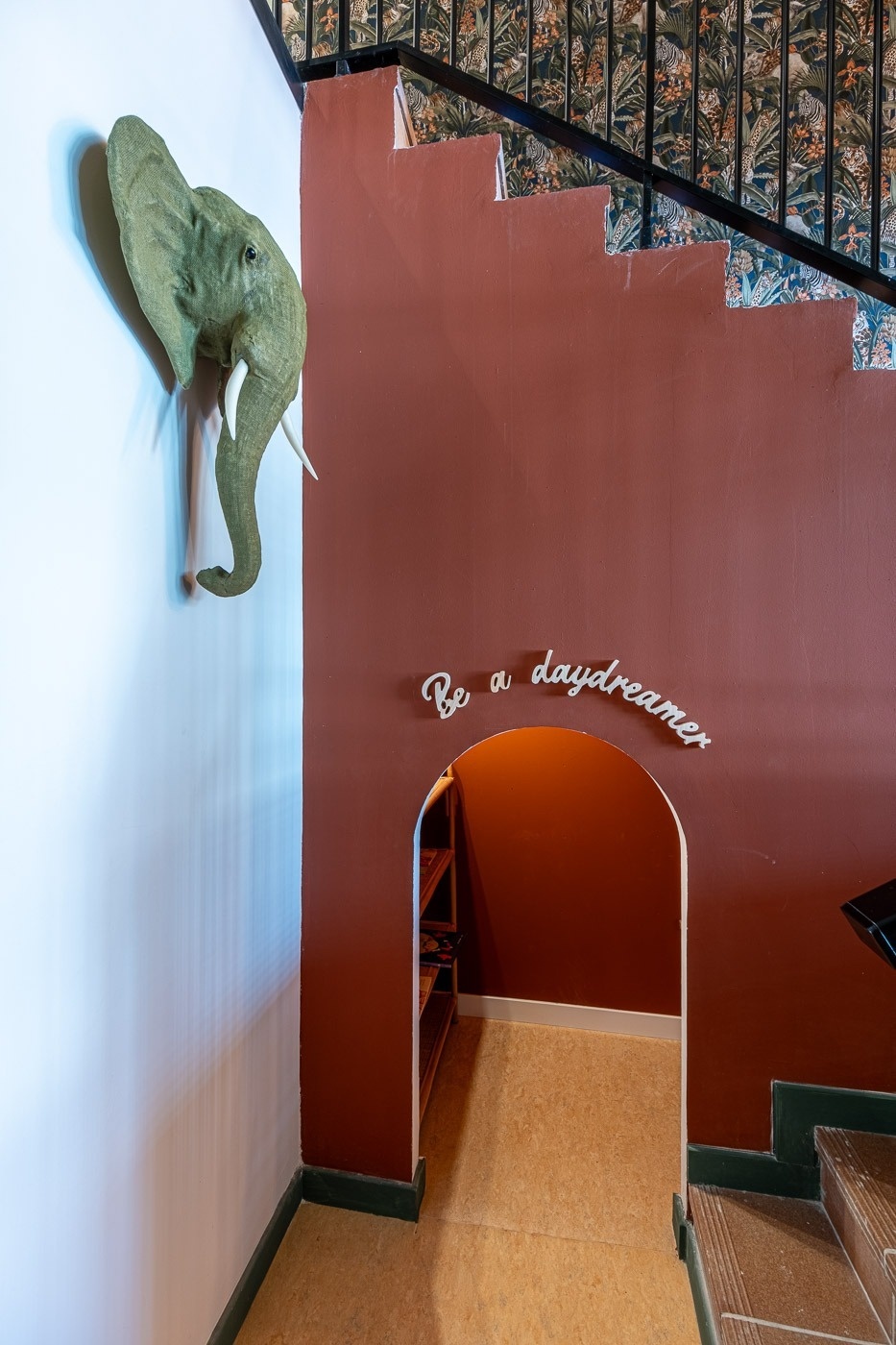 a red wall with the words " be a daydreamer " on it