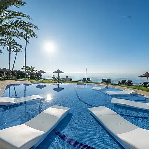 Estival Torrequebrada Benalmádena: Luxurious pool with sun loungers and sea view.