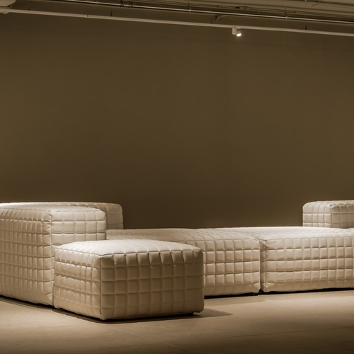 a couch and ottoman in a room with a brown wall