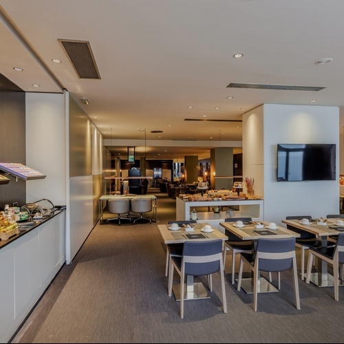 a restaurant with tables and chairs and a tv on the wall