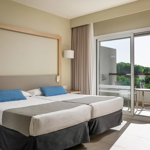 Modern hotel suite with sofa, armchair, and balcony view at Estival Park Almaris, Official Web