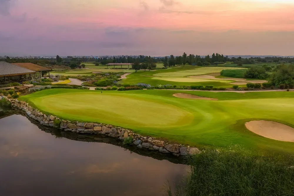 ESTIVAL: Corporate golf course with lake and sunset.