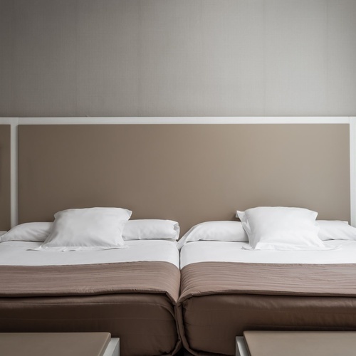 una habitación de hotel con dos camas y dos mesitas de noche