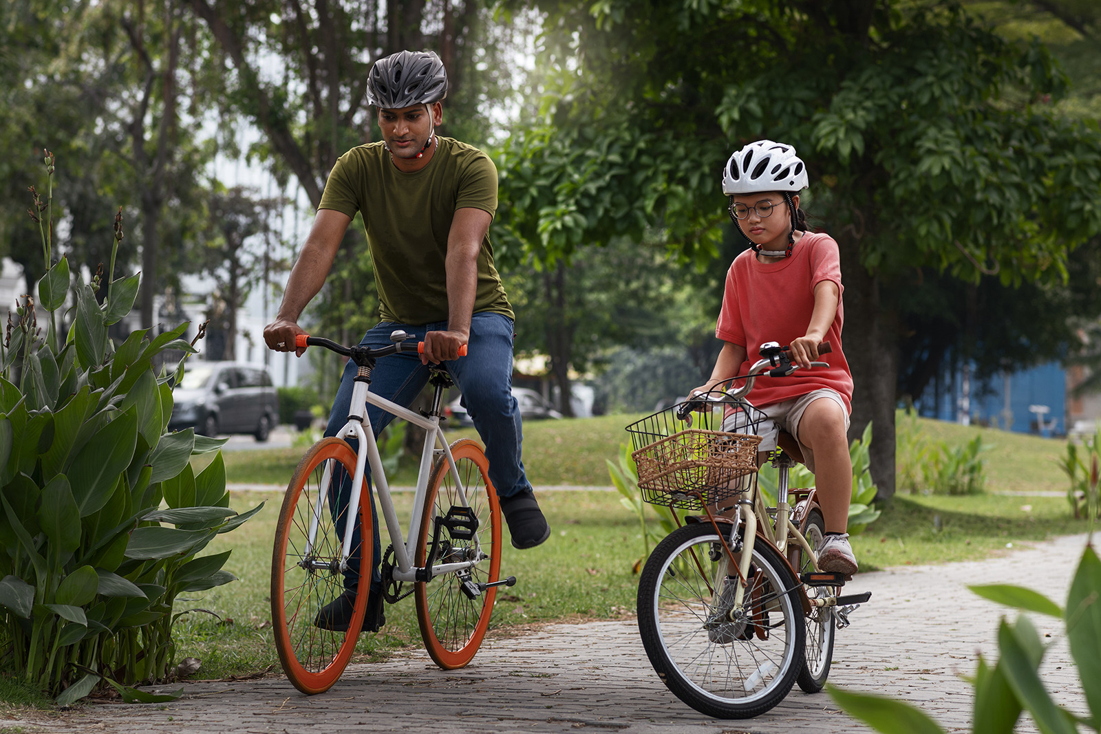 Homme et enfant à vélo dans un parc, parfait pour des vacances en famille ESTIVAL: Corporativa.