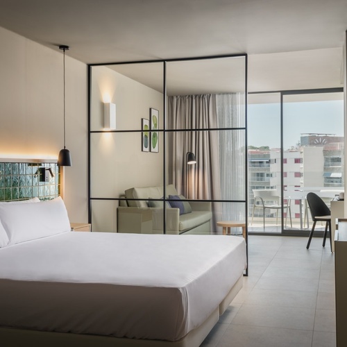 a hotel room with a king size bed and sliding glass doors