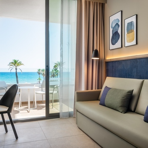 a room with a couch and a desk with a view of the ocean
