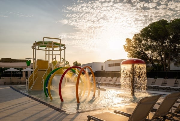 a boy and a girl are playing in a fountain