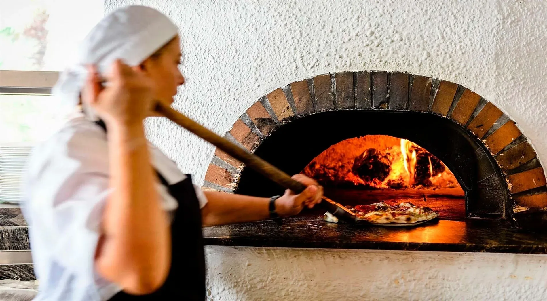 Chef horneando pizza en horno de leña, Gastronomía Estival Eldorado 4* Superior Huelva