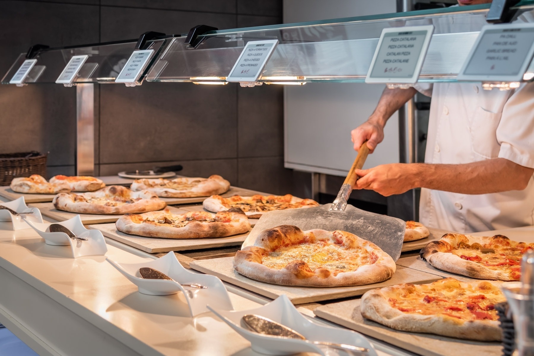 a man is taking a pizza out of the oven at a restaurant