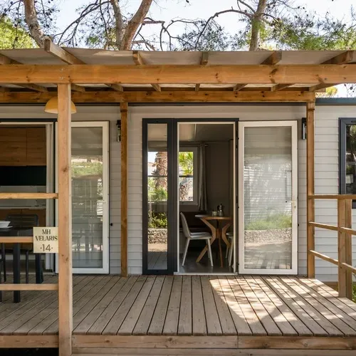 Terrasse couverte avec tables et chaises devant une chambre à Estival Torre de la Mora | Estival Group | Tarragone.