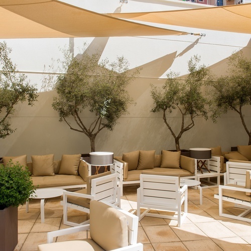 a patio with a couch and chairs under an umbrella