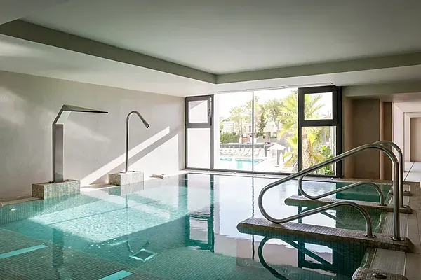 ESTIVAL: Indoor pool with waterfalls and outdoor terrace access.
