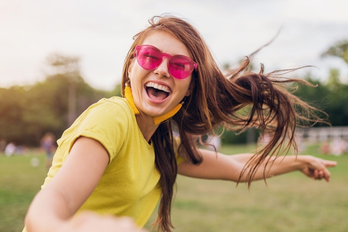 una mujer con gafas de sol rosas sostiene la mano de un hombre