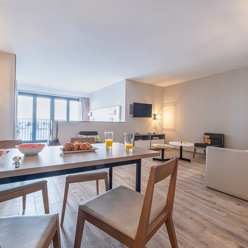 a living room with a dining table and chairs