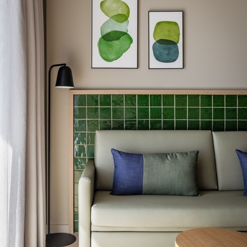 a living room with a couch and two paintings on the wall