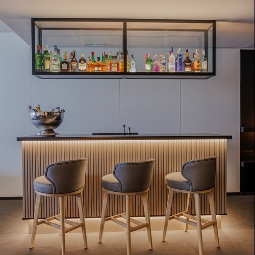 a glass of wine sits on a table while a waitress prepares food