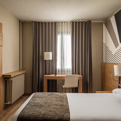 Modern hotel room with two beds, open closet, and mountain views. Hotel Sporting Andorra | Grandvalira Pas de la Casa | Official Web