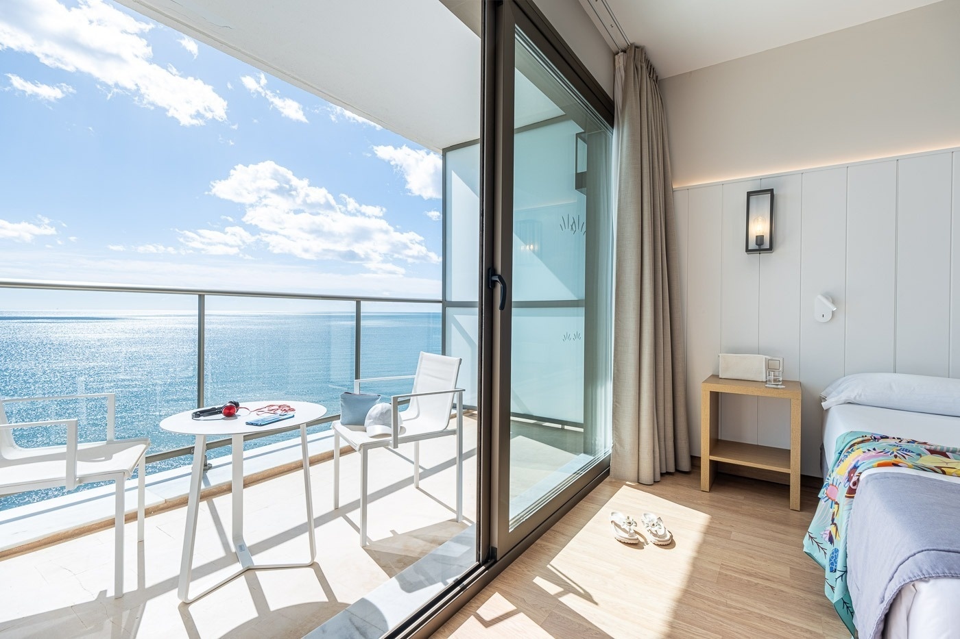 a hotel room with a balcony overlooking the ocean