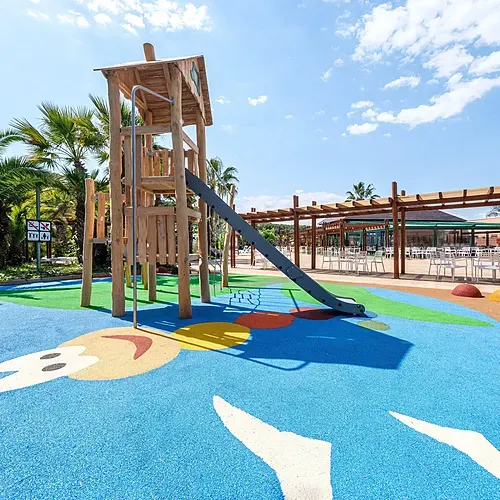 Aire de jeux pour enfants colorée avec toboggan et palmiers au Estival Torre de la Mora | Estival Group | Tarragone | Site officiel.