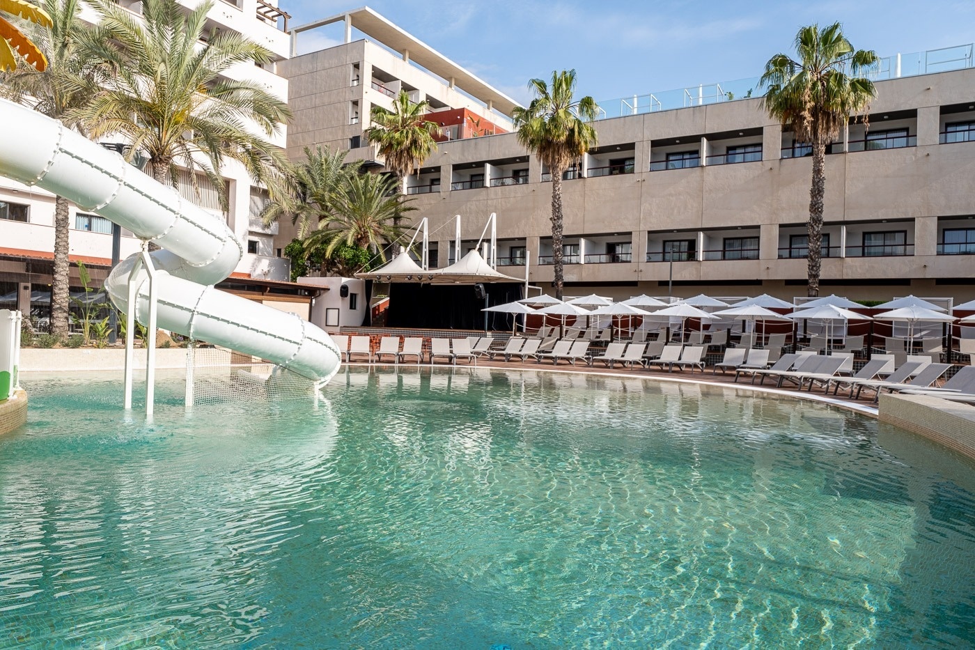 a large swimming pool with a water slide in the middle