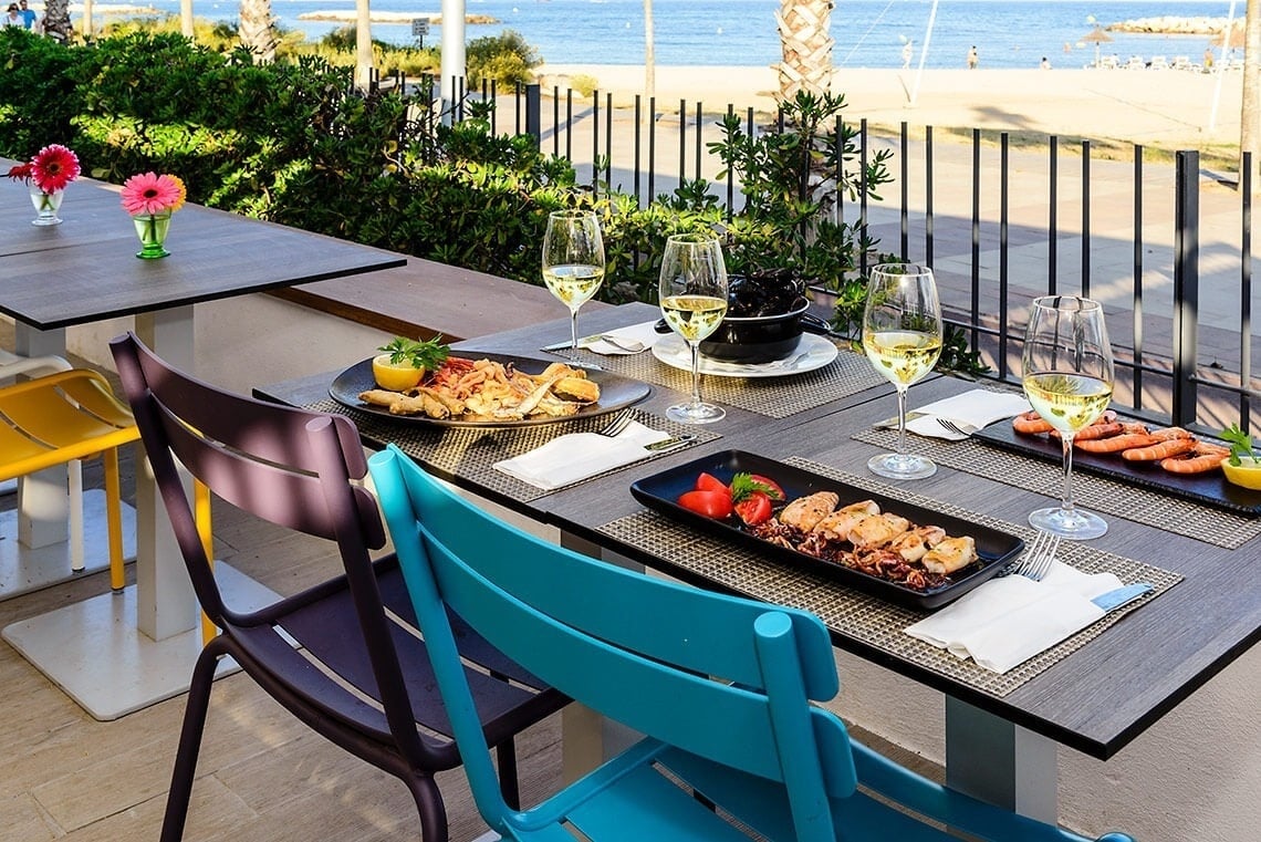 Tables dressées en terrasse avec vue sur la plage, idéales pour profiter du Beach Club Eldorado | Estival Eldorado | Cambrils | Site Web Officiel.