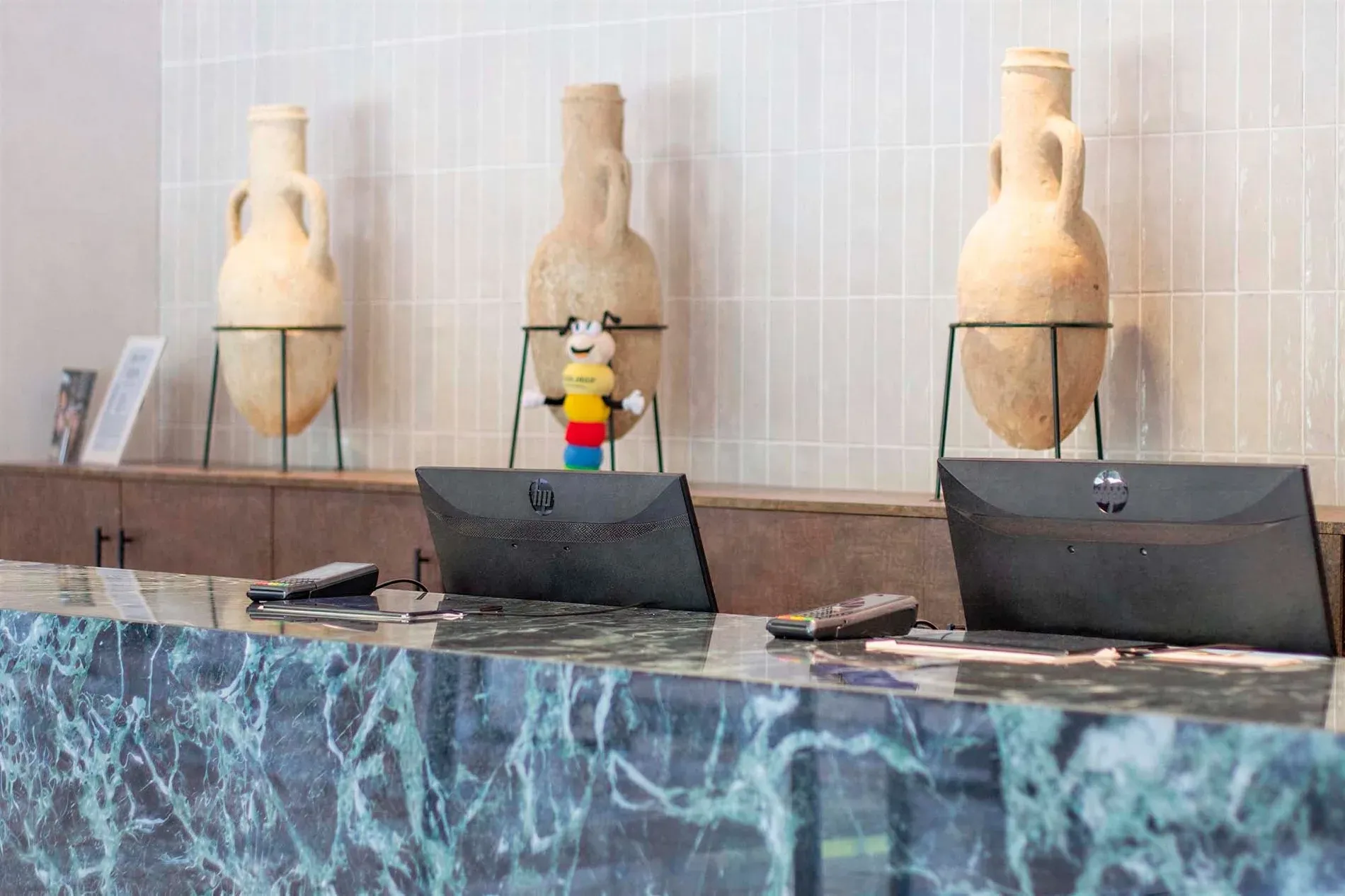 Reception desk with monitors and amphorae, FAQs | Estival Park Almaris | Tarragona