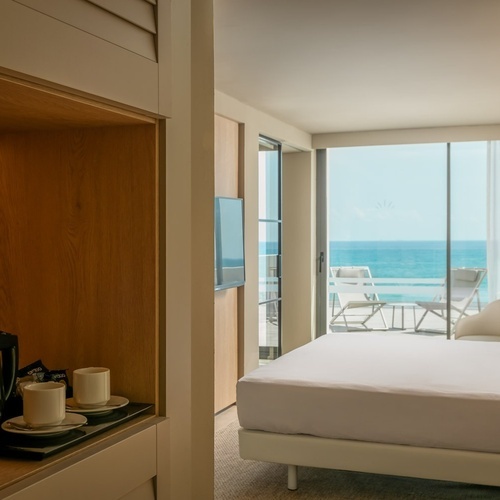 a hotel room with a large bed and a view of the ocean