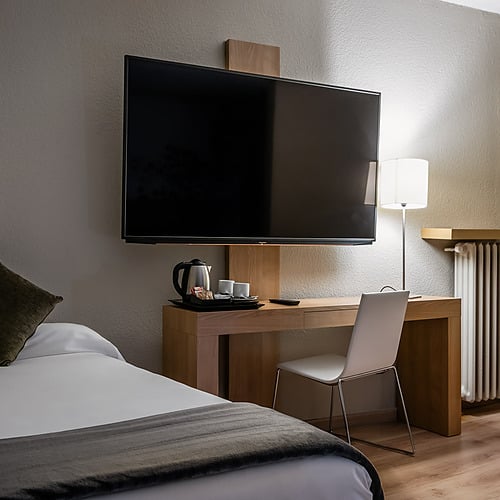 Hotel room with closet, bed, and window view. Hotel Sporting Andorra | Grandvalira Pas de la Casa | Official Web