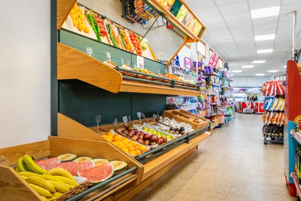 un puesto de frutas y verduras en un supermercado