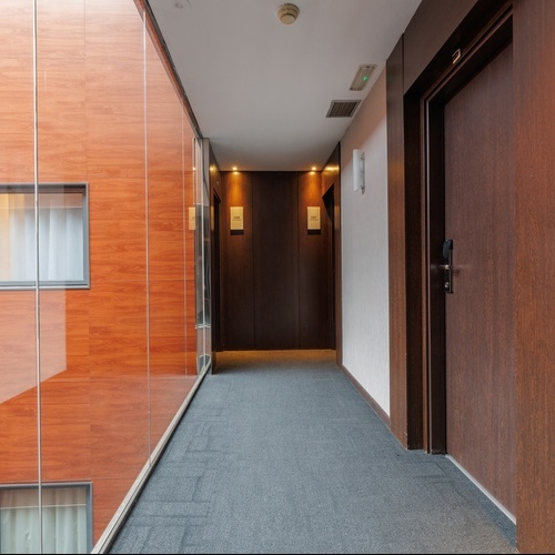 a hallway with a glass wall and a wooden door