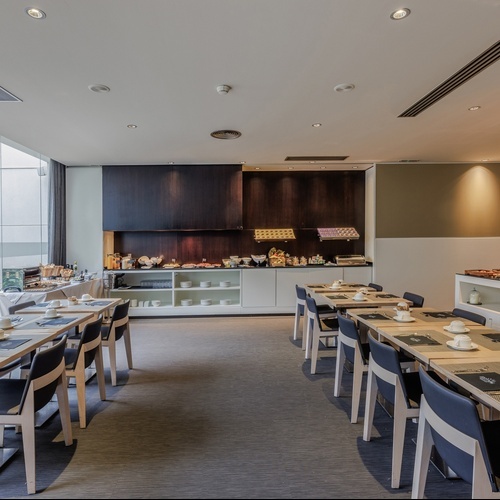a dining room with tables and chairs and a buffet