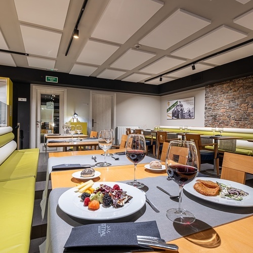 a restaurant with plates of food and glasses of wine