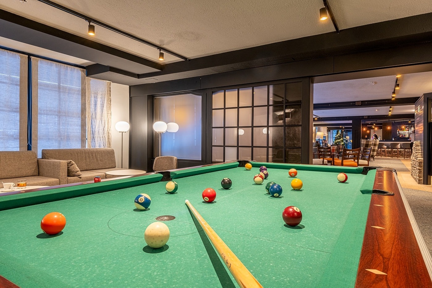 a pool table with balls and cues in a living room
