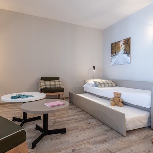 a bedroom with a teddy bear on the bed