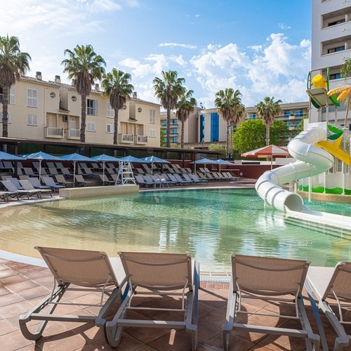 a large swimming pool with a water slide in the middle