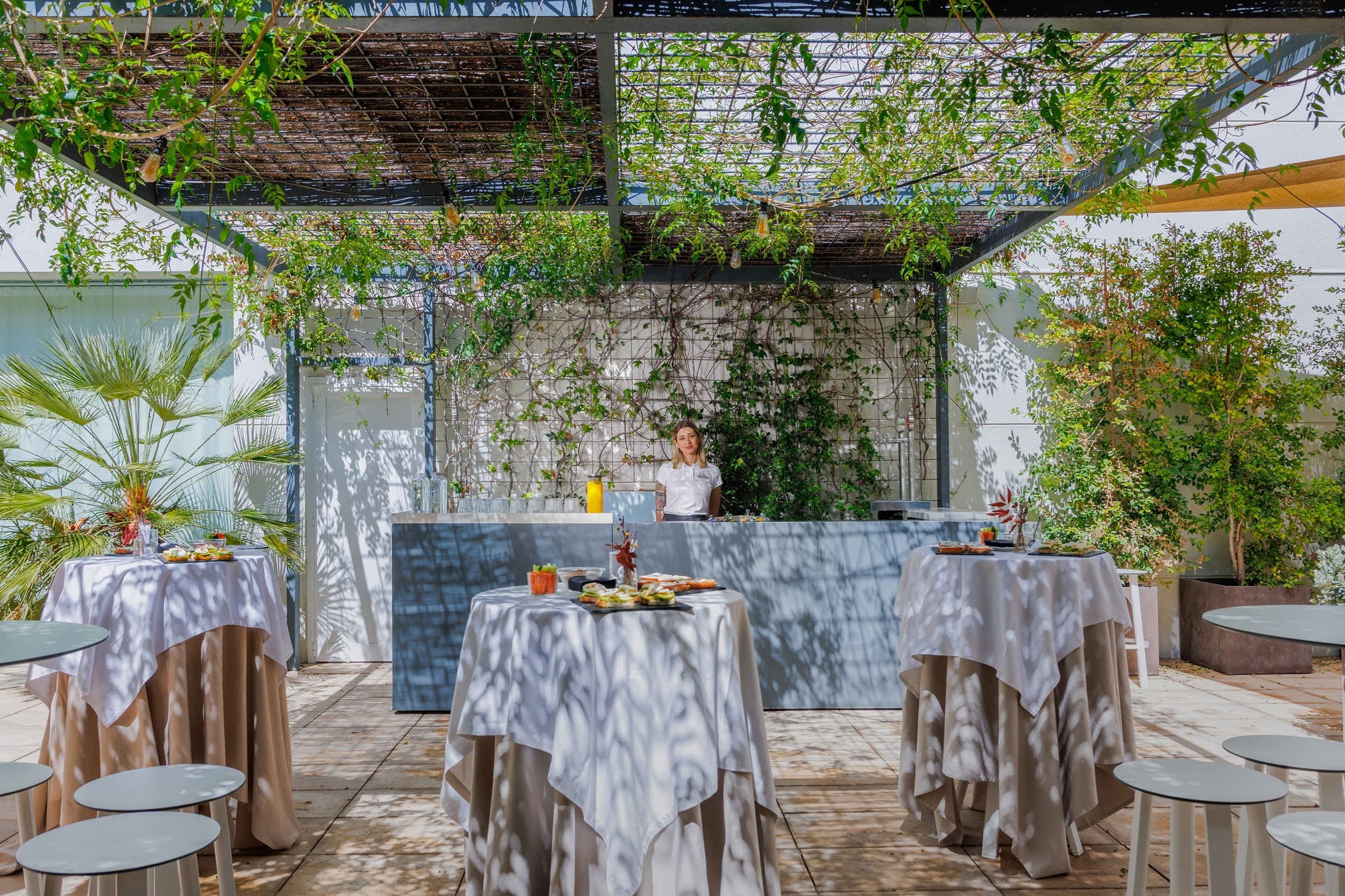 una taula coberta amb una tova blanca i un bar a l' aire lliure