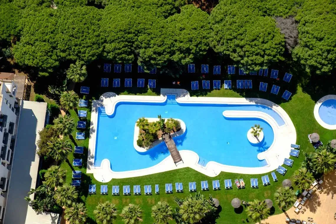 ESTIVAL: Piscina resort con hamacas y palmeras, ideal para corporativas.