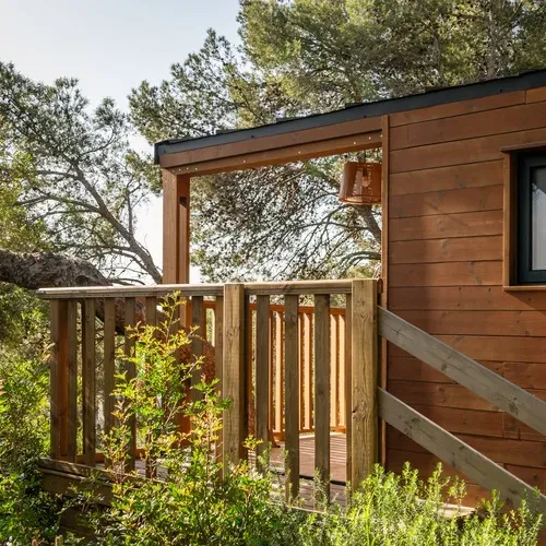 Estival Torre de la Mora : chalet en bois niché dans la verdure, vue sur pinède, Tarragone.