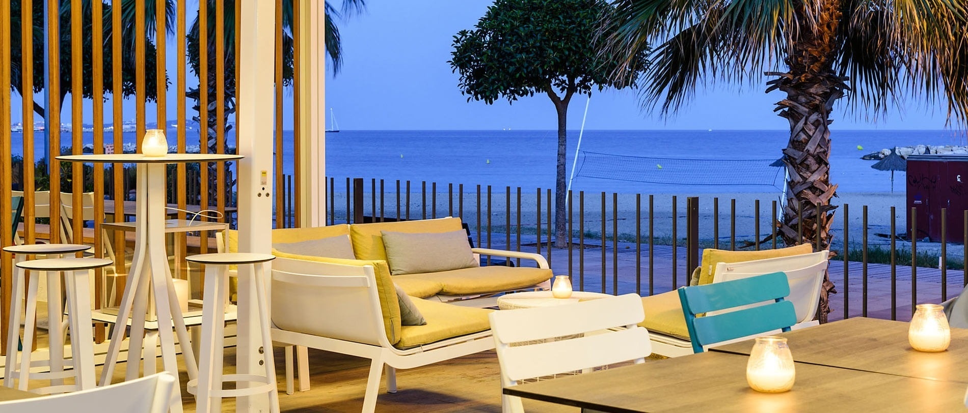 a view of the ocean from a restaurant with tables and chairs