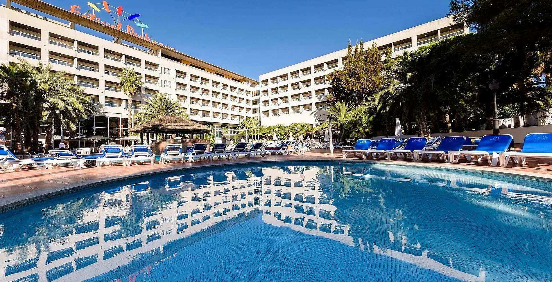 Piscina y hotel ESTIVAL: Corporativa, con tumbonas y palmeras.