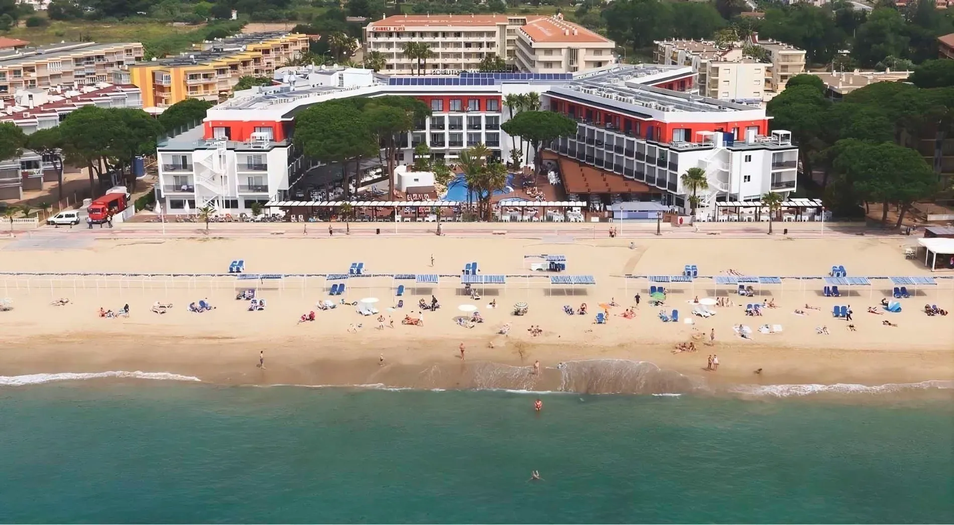 ESTIVAL: Firmen-Luftaufnahme Strandhotel, Pool und genießende Menschen.