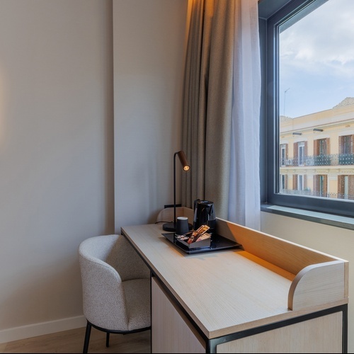 a hotel room with a desk and chair and a window