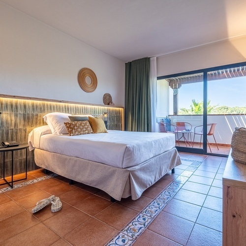 a bedroom with a large bed and a sliding glass door